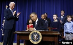 Presiden AS Barack Obama menandatangani perintah eksekutif mengenai kekerasan bersenjata di Gedung Putih, Washington, 2013.