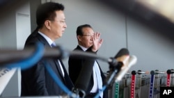 North Korea's First Vice Foreign Minister Kim Kye Gwan, right, waves as he arrives in Beijing, China, June 18, 2013.