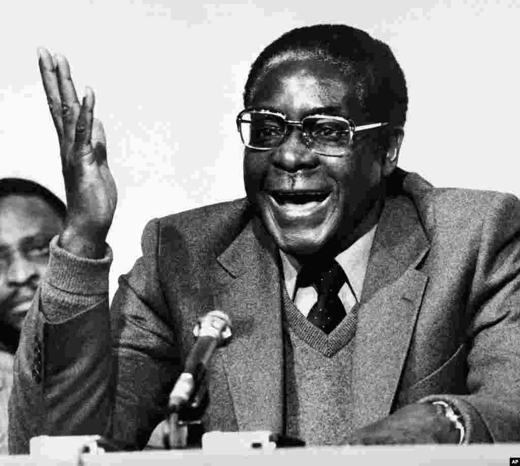 Robert Mugabe ko-lidè nan fòs geriya Front Patriyotik la pandan yon konferans pou laprès nan Lond, 19 desanm 1979, kote li tap anonse li menm ak Joshua Nkomo te rive jwenn yon akò nan Kay Lancaster a, Lancaster House sou yon nouvo konstitisyon, epi aranjman yon tranzisyon ak seselefe. (Foto: AP)
