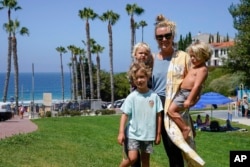 Hillary Salway poses for a photo with her children - Dane Salway, 5, Mick Salway, 1, and Beaux Salway, 3 - on Monday, July 13, 2020, in San Clemente, Calif. Salway plans to send her children back to school in the fall.