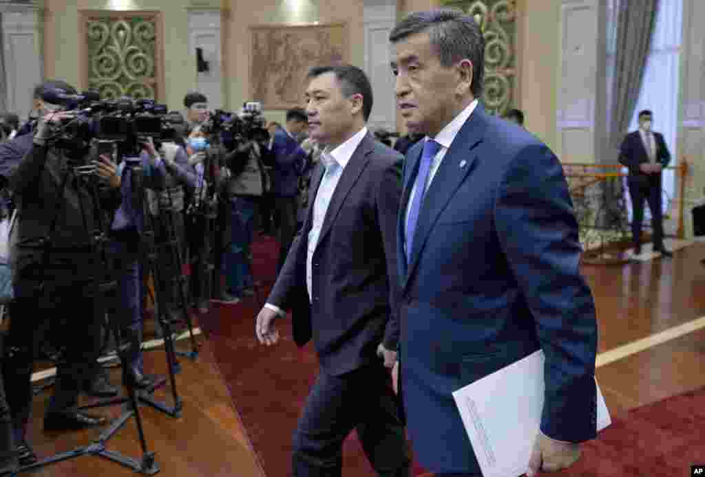 Kyrgyzstan&#39;s President Sooronbai Jeenbekov, right, and Prime Minister Sadyr Zhaparov arrive to attend an official ceremony of transfer of power at the Kyrgyzstan Parliament in Bishkek, Kyrgyzstan, Friday, Oct. 16, 2020. Kyrgyzstan&#39;s embattled president ha
