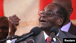 Zimbawe's president, Robert Mugabe, gestures as he addresses supporters of his ruling ZANU-PF party at Harare International Airport, Zimbabwe, Sept. 24, 2016. 