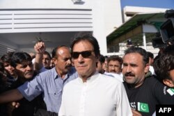 FILE - Imran Khan, head of the Pakistan Tehrik-e-Insaf (PTI) political party, leaves Parliament after attending a session in Islamabad, May 23, 2018.