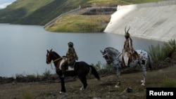 Deux habitants du Lesotho portent des costumes traditionnels lors de la cérémonie d'ouverture de la première phase du projet "Highlands water project", le 16 mars 2004.
