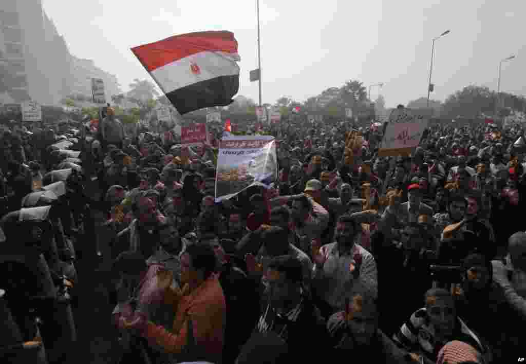 Supporters of Egyptian President Mohamed Mursi shout slogans as riot police form a line in front of the Supreme Constitutional Court in Maadi, south of Cairo, on the outskirts of Cairo, December 2, 2012. 