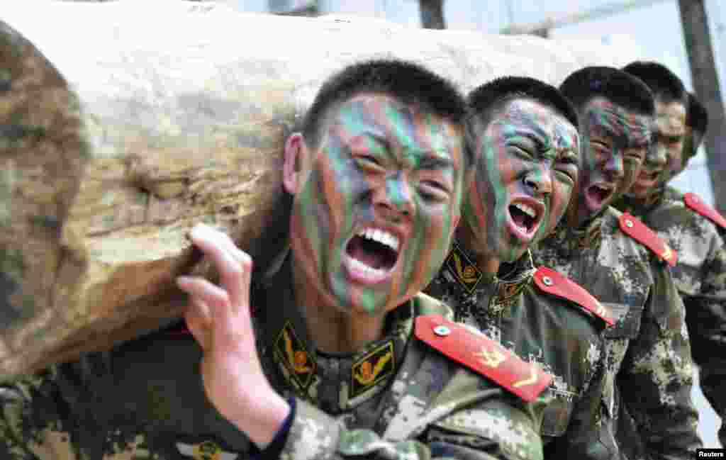 Paramilitary policemen shout as they lift a log during a winter training session at a military base in Chaohu, Anhui province, China.