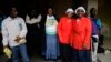 Cleaning staff watch a service for former South African President Nelson Mandela at the First National Bank Stadium, also known as Soccer City, in Johannesburg, Dec.10, 2013. 