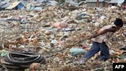 FILE - Young Cambodian boy pulls bicycle tires at Stung Meanchey rubbish dump, Phnom Penh.