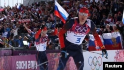 Russia's Alexander Legkov and Ilia Chernousov (L) race to the finish line to take first and third place in the men's cross-country 50 km mass start free event at the Sochi 2014 Winter Olympic Games, Feb. 23, 2014.