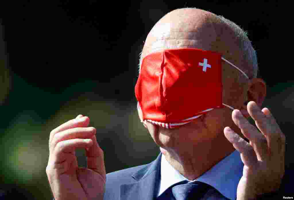 İsveçin maliyyə naziri Ueli Maurer Avstriya kansleri Sebastian Kurzu qarşılamaq mərasimindən öncə üzünə maska taxır.&nbsp;