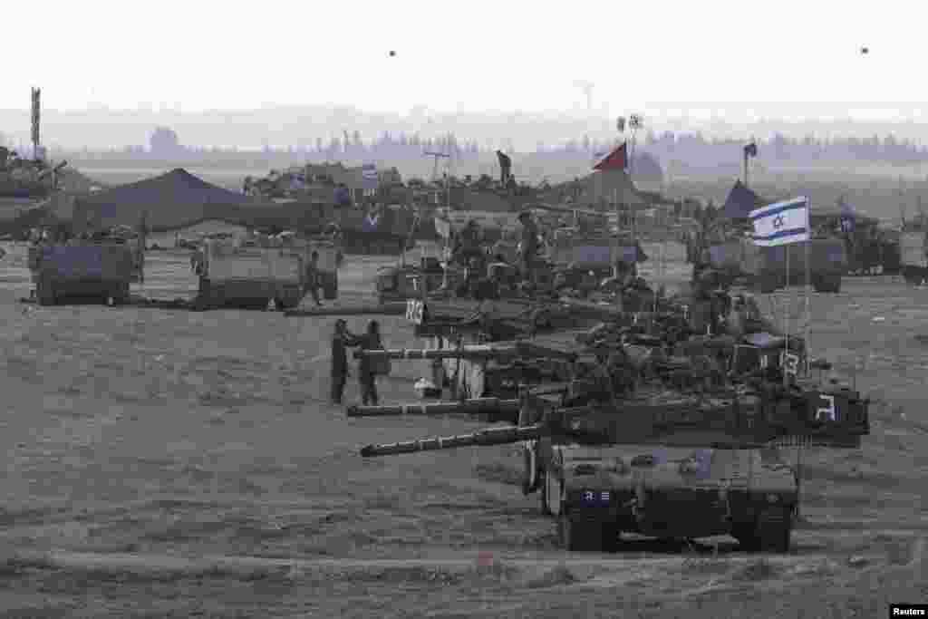 Israeli tanks and armored personnel carriers are seen at a staging area outside the Gaza Strip, July 15, 2014.