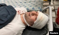 FILE - Blogger Miraziz Bazarov lies on a stretcher upon his arrival at a hospital after he was beaten by a group of unidentified men in Tashkent, Uzbekistan, March 29, 2021.