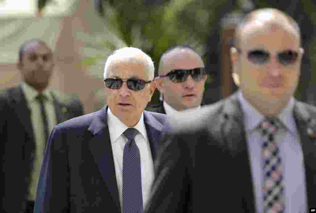 Egyptian bodyguards flank Arab League Secretary-General Nabil Elaraby, second left, upon his arrival at the league's headquarters in Cairo, Egypt, Sept. 8, 2014.