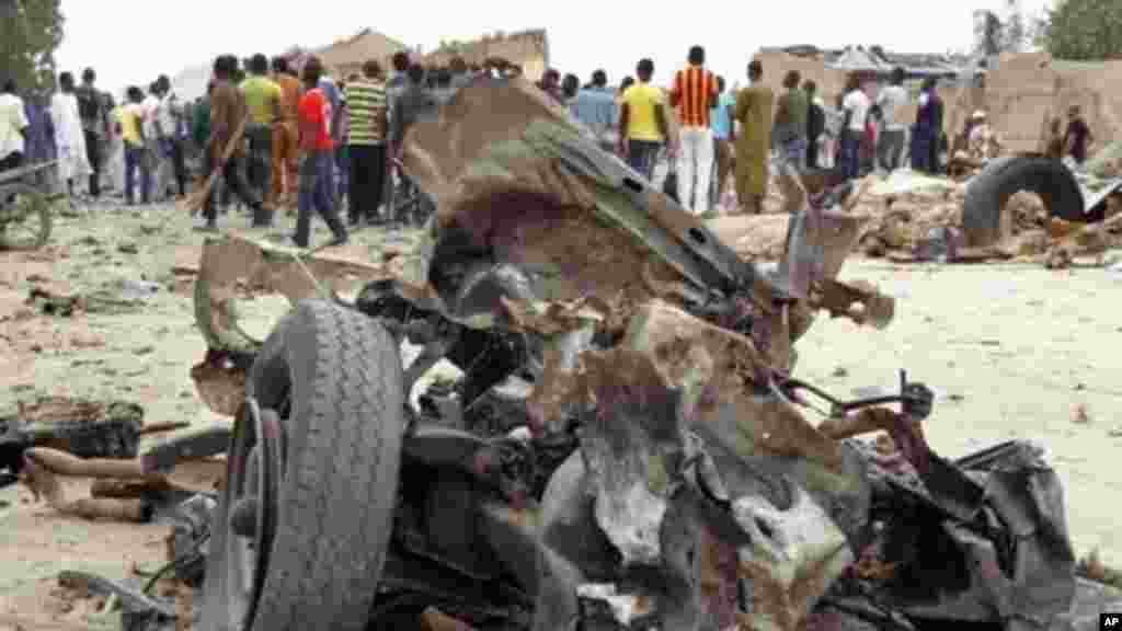Mutane sunyi dafifi kewaye da inda daya daga cikin boma-boman ya tashi domin ganewa idanusu a Ajilari-Gomari kusa da filin jirgin sama na Maiduguri a ranar 2 ga watan Maris 2014.