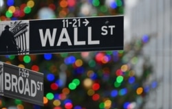 Wall Street sign at the New York Stock Exchange (NYSE) on December 9, 2020 in New York City. (Photo by Angela Weiss / AFP)