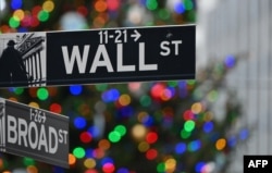 Wall Street sign at the New York Stock Exchange (NYSE) on December 9, 2020 in New York City. (Photo by Angela Weiss / AFP)