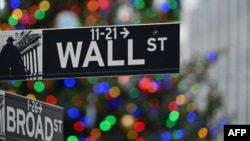 Wall Street sign at the New York Stock Exchange (NYSE) on December 9, 2020 in New York City. (Photo by Angela Weiss / AFP)