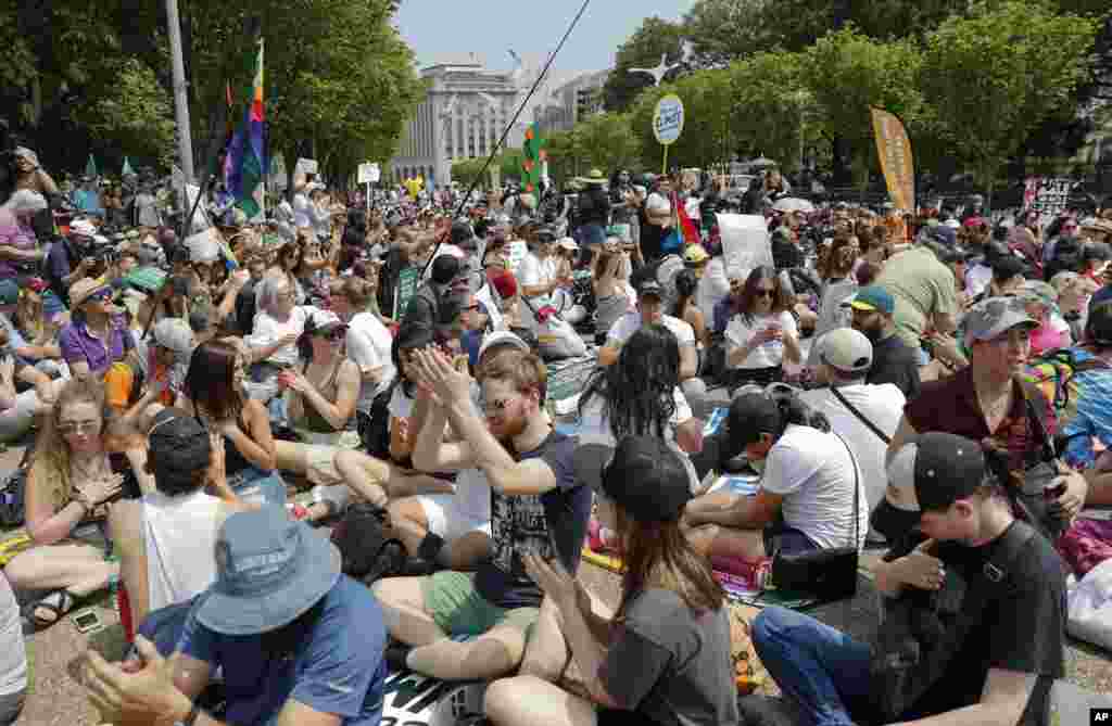 Demonstrators sit on the ground along Pennsylvania Ave. in front of the White House in Washington during a demonstration and march, April 29, 2017.