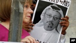 People hold signs during a protest at the Embassy of Saudi Arabia in Washington about the disappearance of Saudi journalist Jamal Khashoggi, Oct. 10, 2018. 