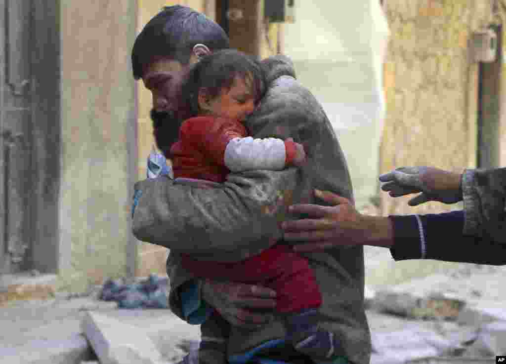 A boy holds his baby sister, who survived what activists say was an airstrike by forces loyal to Syrian President Bashar al-Assad in Masaken Hanano in Aleppo.
