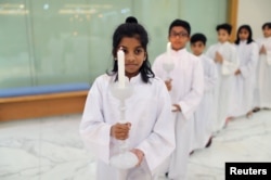 Expat children hold the candles while serving during the Mass at St. Francis of Assisi Catholic Church in Jebel Ali, in Dubai, UAE Jan. 18, 2019.