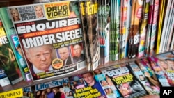FILE - This July 12, 2017, file photo shows the cover of an issue of the National Enquirer featuring President Donald Trump at a store in New York. Karen McDougal, a former Playboy model who said she had a 10-month affair with Trump, setttled her lawsuit on April 18, 2018, with the supermarket tabloid.