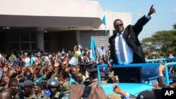 FILE - Newly elected Malawian president Peter Mutharika greets supporters after he was sworn in at the High Court in Blantyre, Malawi, May 31, 2014.