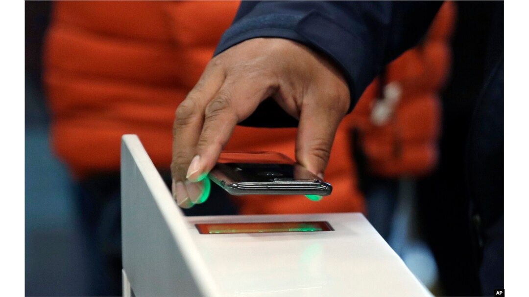 FILE - A shopper scans an Amazon Go app on a cellphone while entering an Amazon Go store, Jan. 22, 2018, in Seattle, Washington.