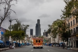 Sebuah ambulance terlihat di kawasan Skid Row di pusat kota Los Angeles, California, 12 April 2020. (Foto: AFP)