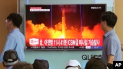 FILE - In this July 29, 2017 photo, People watch a TV news program showing an image of North Korea's latest test launch of an intercontinental ballistic missile (ICBM), at the Seoul Railway Station in Seoul, South Korea.