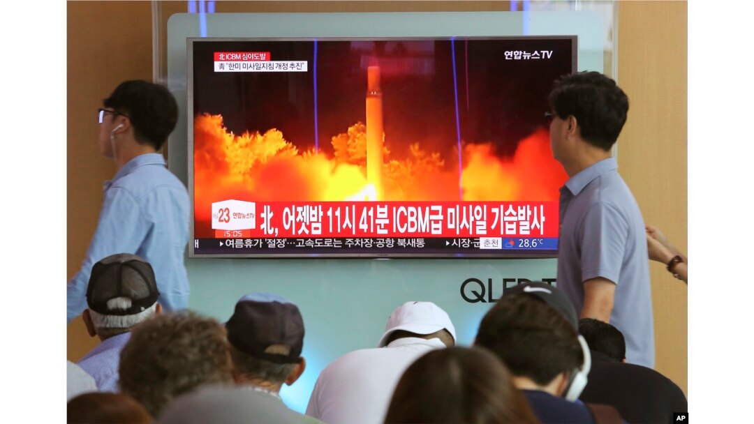 FILE - In this July 29, 2017 photo, People watch a TV news program showing an image of a North Korea's test launch of an intercontinental ballistic missile (ICBM), at the Seoul Railway Station in Seoul, South Korea.