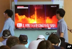 FILE - In this July 29, 2017 photo, People watch a TV news program showing an image of a North Korea's test launch of an intercontinental ballistic missile (ICBM), at the Seoul Railway Station in Seoul, South Korea.