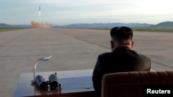 Kim Jong observant le lancement d'un missile Hwasong-12. Photo publiée par l'Agence de presse de Corée du Nord (KCNA) le 16 septembre 2017.