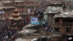 Tín đồ Hindu ở Nepal kéo dây thừng buộc vào chiếc xe ngựa của thần Hindu Bhairava giữa những căn nhà bị phá hủy trong trận động đất năm ngoái tại lễ hội Bisket Jatra ở Bhaktapur, Nepal, ngày 13/4/2016.