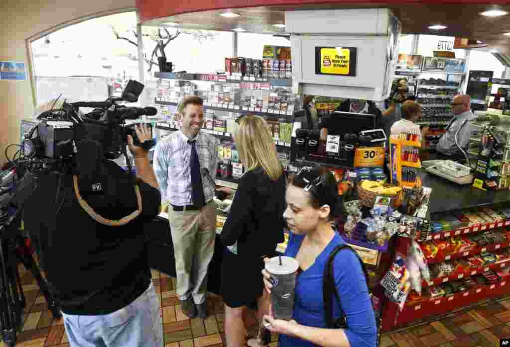 Eric Seitz, second from left, store owner of at 4 Sons Food Store, talks about his store selling one of the winning tickets in the $579.9 million Powerball jackpot in Fountain Hills, Arizona, November 29, 2012.