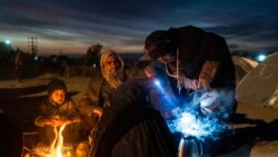 FILE - A family prepares tea outside the Directorate of Disaster office where they are camped, in Herat, Afghanistan, on Nov. 29, 2021.