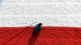 Seorang pria mempersiapkan bendera raksasa sebelum mengibarkannya pada perayaan hari kemerdekaan di Universitas Kristen Petra di Surabaya, Jawa Timur. (Foto: REUTERS/Sigit Pamungkas)