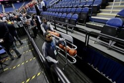 Personel remove the balls from the playing court after the NCAA college basketball games were cancelled at the Atlantic Coast Conference tournament in Greensboro, N.C., Thursday, March 12, 2020.