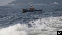 A man fishes on the Guanabara Bay in Rio de Janeiro, Brazil, Thursday, April 10, 2014. Many had hoped authorities tackle decades of neglect and poor planning that have blighted waterways, after Rio's Olympic committee pledged in writing that the pollution of Guanabara Bay will be fixed. (AP Photo/Silvia Izquierdo)