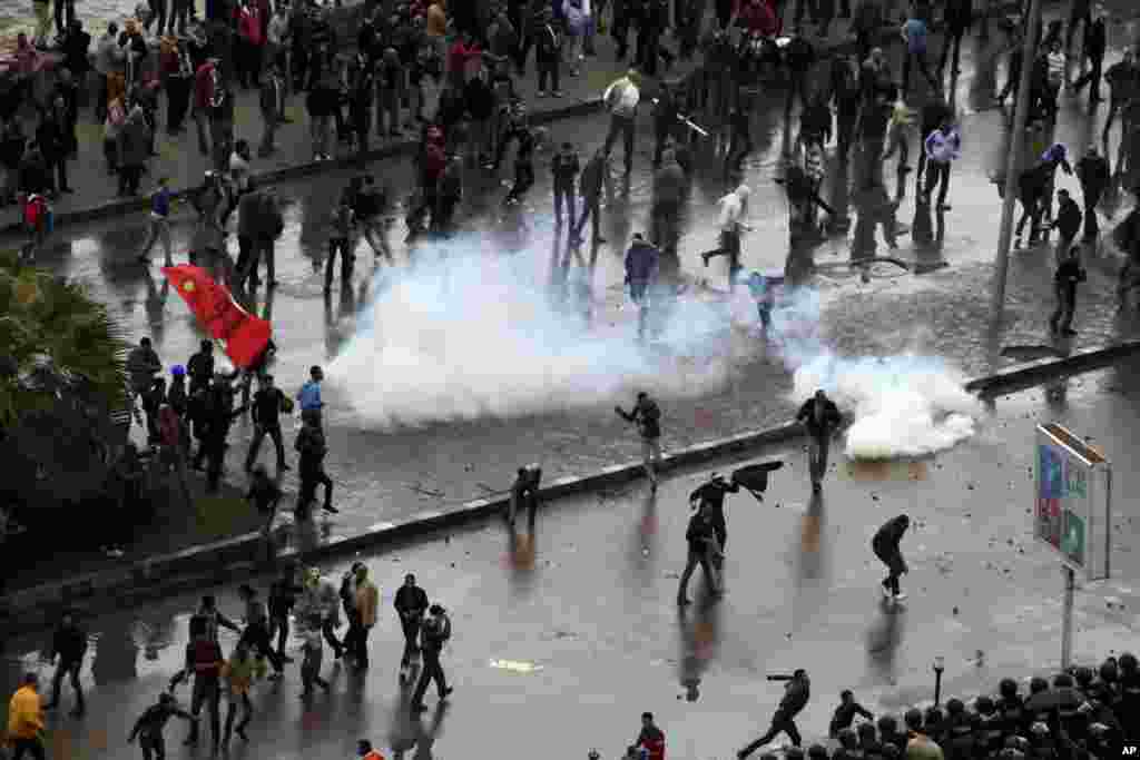 Opponents of Egyptian President Mohamed Morsi clash with Islamist supporters of the president, unseen, as a cordon of riot police separates the groups in Alexandria, Egypt, December 21, 2012.