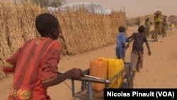 Des enfants apportent de l'eau dans le camp de réfugiés d'Assaga, Diffa, Niger, le 17 avril 2017. (VOA/Nicolas Pinault)