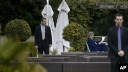 Le Secrétaire d'Etat américain John Kerry, centre droit, épulche des documents dans une cour, au Beau Rivage Palace Hôtel, au cours d'une ronde d'extension des pourparlers sur le programme nucléaire de l'Iran, le jeudi 2 Avril 2015 à Lausanne, Suisse.