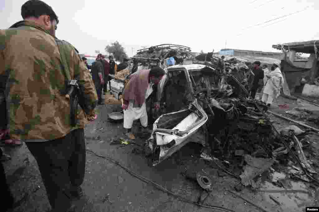 A man looks into a car, which was damaged during a bomb attack at Fauji Market in Peshawar December 17, 2012. The blast in the market in northwest Pakistan on Monday killed at least 15 people, a security official said. The official said at least 20 people