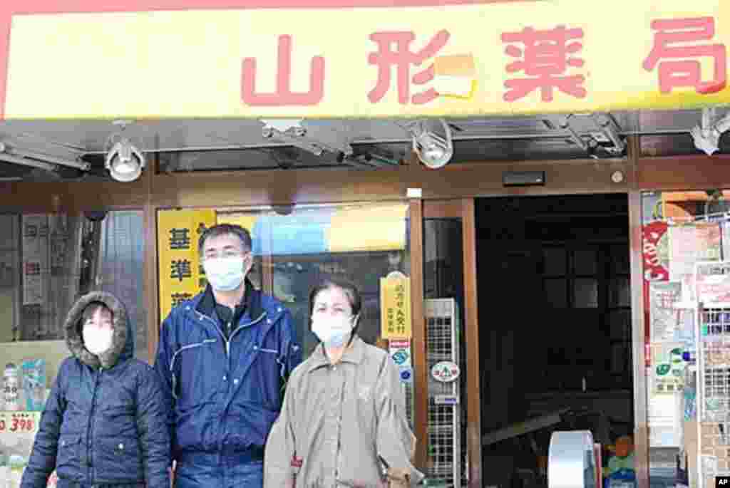 The Yamagata family in front of their quake-damaged pharmacy in Namie, Fukushima Prefecture, Japan March 12 2011 (VOA - S. L. Herman)