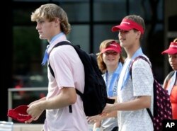 Kids wear visors and cooling neckerchiefs given to them by firefighters in downtown Phoenix, July 23, 2018.