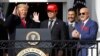 El presidente Donald Trump (izquierda) reacciona mientras el receptor Kurt Zuzuki camina hacia el podio para hablar durante el evento en honor los Nacionales de Washington, ganadores de la Serie Mundial de Beísbol el lunes, 4 de noviembre, de 2019.