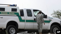 In this April 19, 2011 photo, a National Guardman talks with U.S. Border Patrol agents stationed along the Hidalgo International Bridge in Hidalgo, Texas