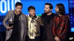 Dan Reynolds, from left, Ben McKee, Daniel Platzman, and Daniel Wayne Sermon of Imagine Dragons accept the award for favorite duo or group at the American Music Awards at the Microsoft Theater in Los Angeles, Nov. 19, 2017.