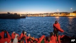 Foto yang diambil pada tanggal 27 Juli 2018 ini menunjukkan para migran yang di atas kapal Spanyol di pelabuhan Tarifa, Spanyol selatan, setelah diselamatkan oleh tim penyelamat maritim Spanyol di Selat Gibraltar.