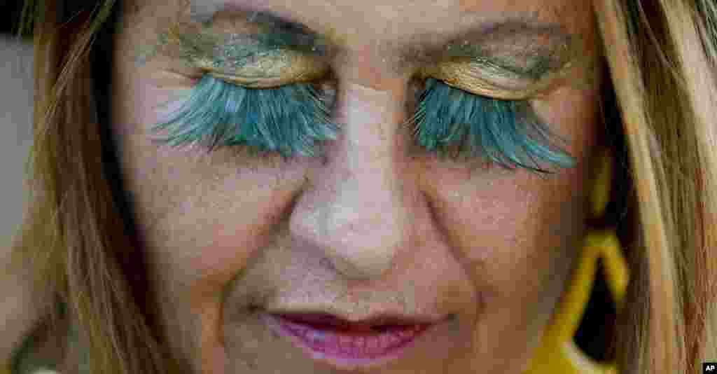A fan from Brazil wears the national colors or her eyelashes as she lines up to enter the Maracana Stadium ahead of the opening ceremony for the 2016 Summer Olympics in Rio de Janeiro, Brazil, Aug. 5, 2016.